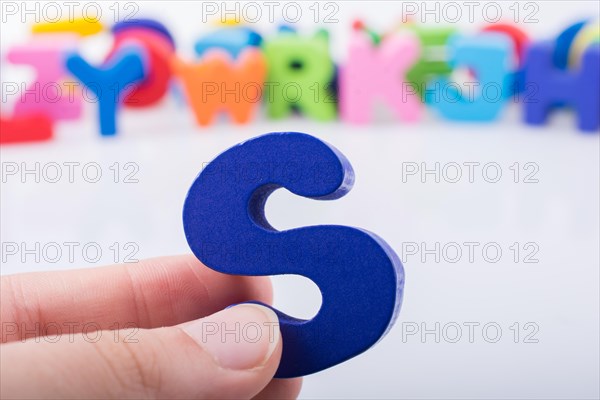 Hand holding letter cube S of made of wood