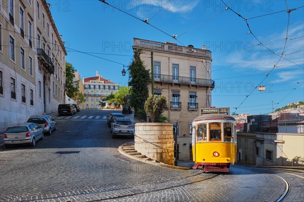 Famous vintage yellow tram 28 in the narrow streets of Alfama district in Lisbon