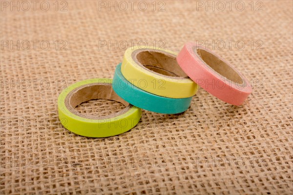 Colorful insulating adhesive tape on linen canvas background