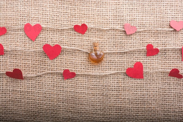 Heart shaped bottle and papers on linen threads