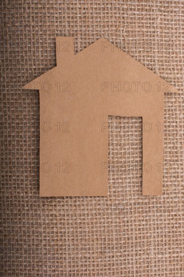 Little paper house placed on a linen canvas