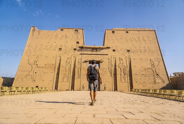 A young tourist entering the Temple of Edfu in the city of Edfu