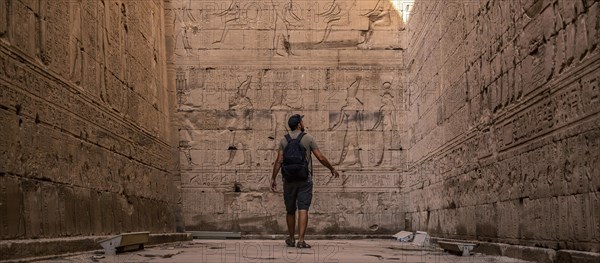 A young tourist visiting the beautiful temple of Edfu in the city of Edfu