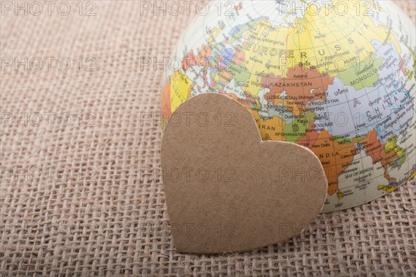 Heart shaped object by a model globe on canvas