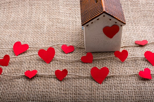 Heart shaped icons and paper house on linen threads