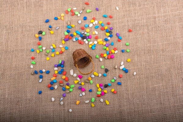 Basket and spilled pebbles on canvas background