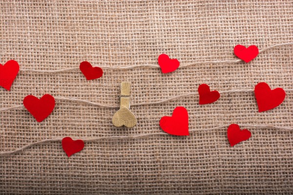 Love concept with heart shaped papers on linen threads