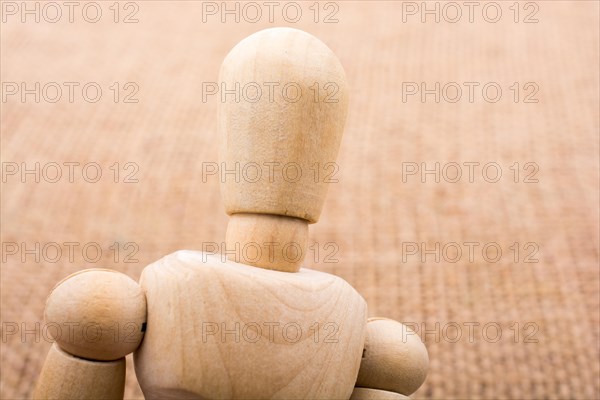 Wooden dolls of a man posing on canvas