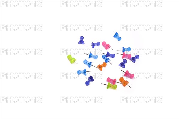 Colorful drawing-pins scattered on a white background