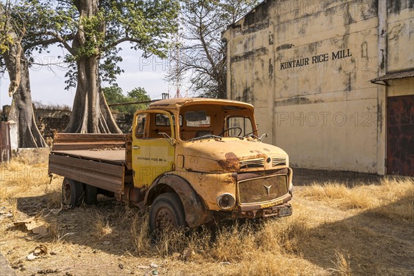 Wrecked truck in front of the abandoned former rice mill in Kuntaur