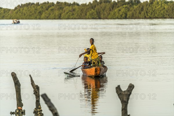 Children fishing from a pirogue on the gambia River