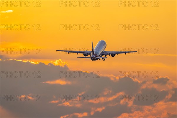 Plane of the airline Eurowings takes off into the dawn at Stuttgart Airport