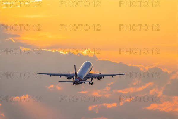 Plane of the airline Eurowings takes off into the dawn at Stuttgart Airport