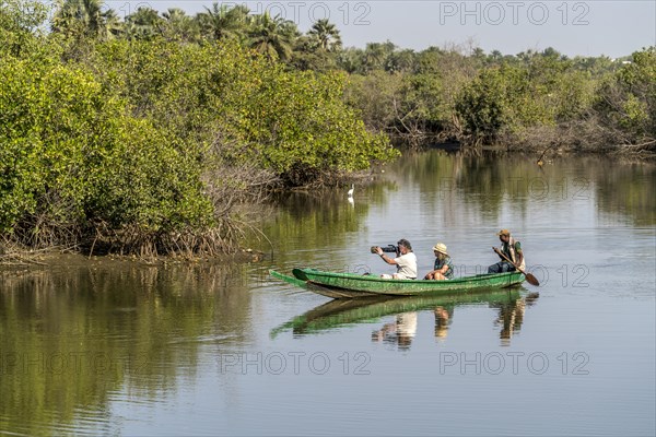 Tourists with canoe on the Kotu River watching and photographing birds
