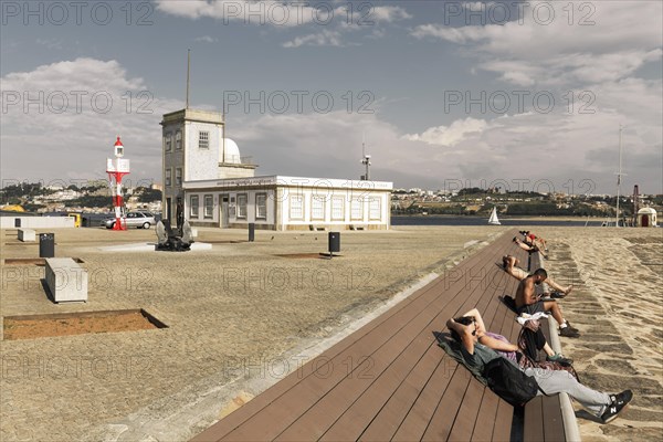 People sunbathing on a bench at the lighthouse of Sao Miguel-O-Anjo