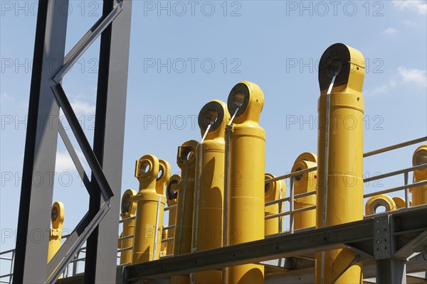 Components for Komatsu mining excavators against a blue sky