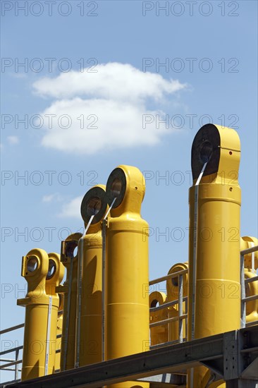 Components for Komatsu mining excavators against a blue sky