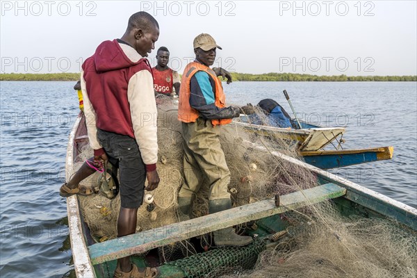 Fishermen with net in their boat on the riverbank