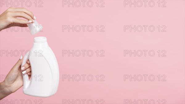 Close up woman opening detergent bottle