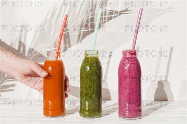 Hand with bottles colorful drinks