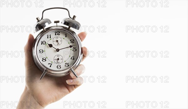 Hand holding alarm clock with copy space