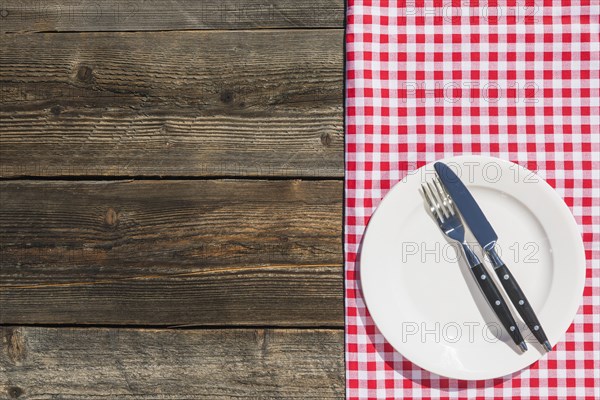 White plate checkered table cloth wooden textured plank