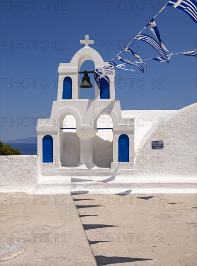 White bell tower with Greek flags