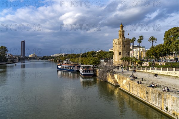 On the banks of the Guadalquivir river with the historic Torre del Oro tower in Seville