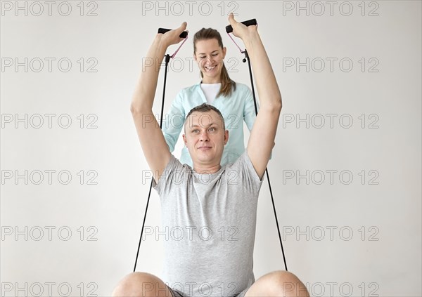 Therapist undergoing physical therapy male patient