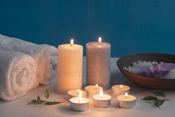 Lighted candles rolled up towel bath spa salt table