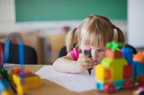 Toddler girl drawing paper classroom