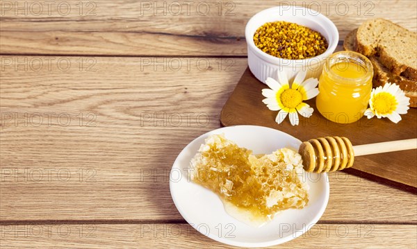 Honeycomb bee pollen honey bread slice wooden surface