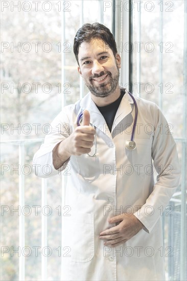 Portrait of a latino doctor looking at the camera giving a thumb up