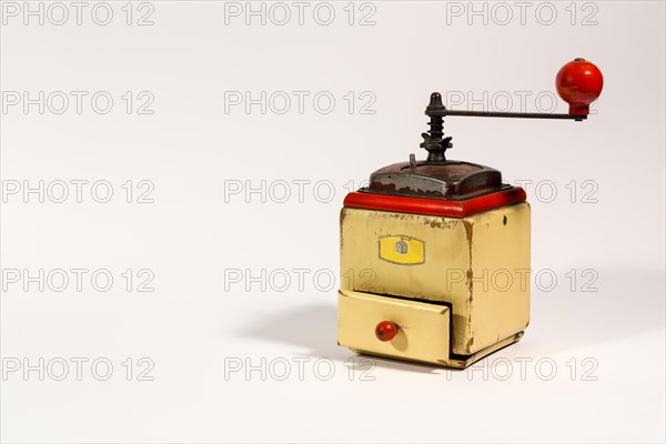 Old wooden colored manual coffee grinder with red handle