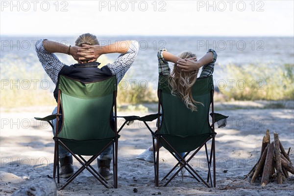 Couple sitting chairs from shot