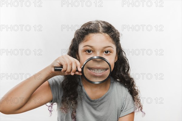 Close up girl with magnifying glass showing her teeth