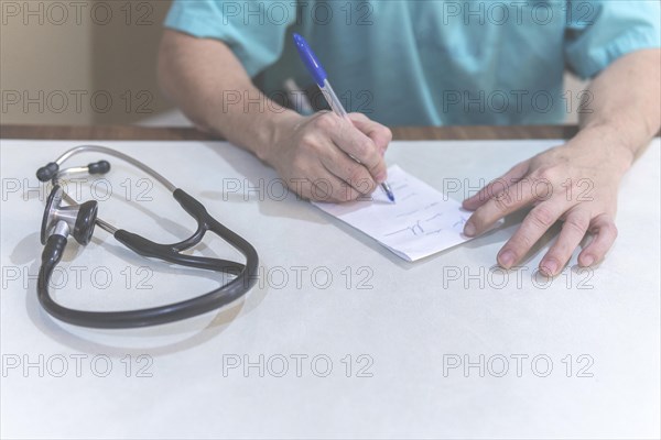 Detail of doctor making a prescription