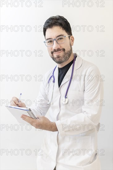 Latin doctor taking notes looking to the camera