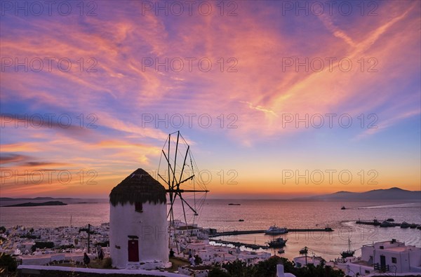 Famous traditional Greek windmill overlook civil port and harbor of Mykonos