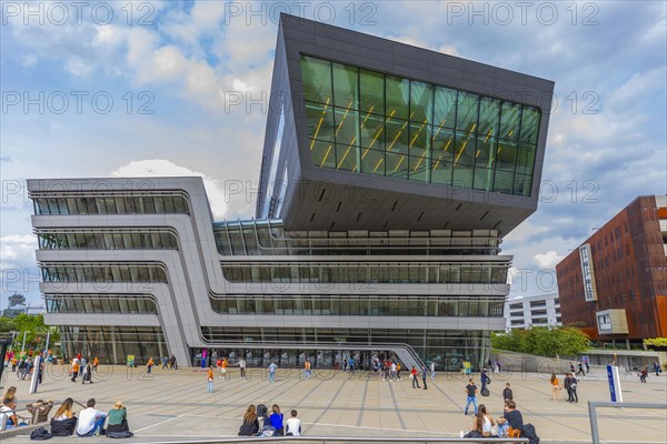 Students in front of modern building on the campus of the University of Economics WU