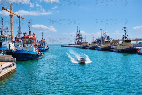 Port of Lisbon with moored tugboats on sunny day. Tagus river