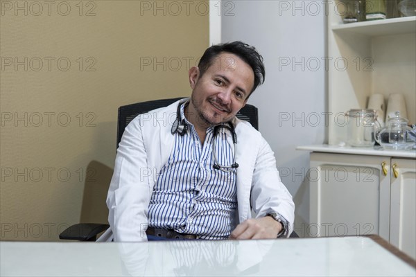 Latin doctor sitting at his desk