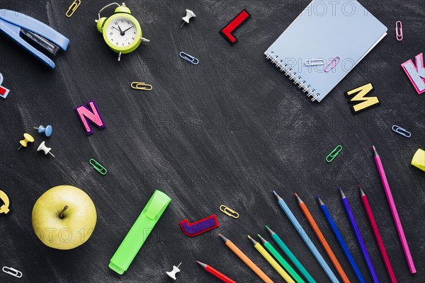 School stationery with apple alarm clock scattered blackboard