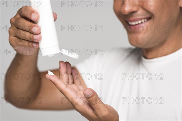 Close up man pouring cream