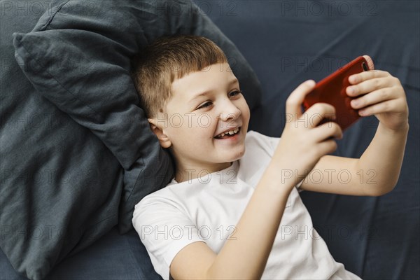 High view child playing mobile phone