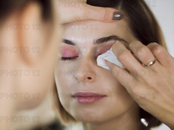 Woman wiping eye makeup model