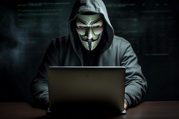 Hacker with Anonymous mask on notebook