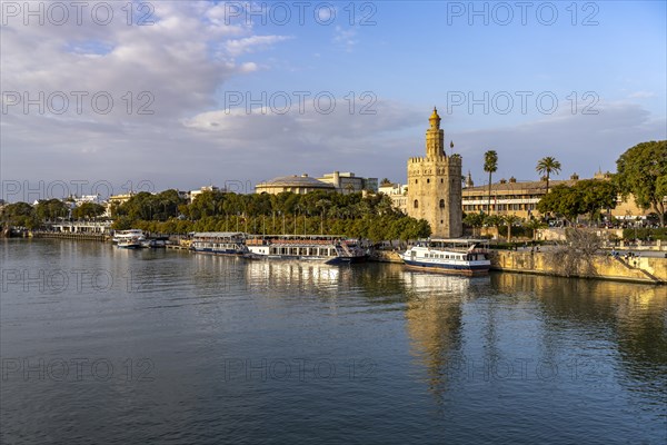 On the banks of the Guadalquivir river with the historic Torre del Oro tower in Seville