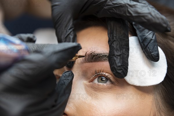 Young woman getting beauty treatment her eyebrows