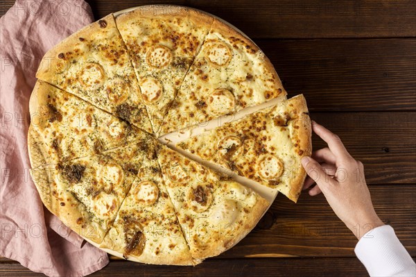 Top view hand taking slice pizza cheese